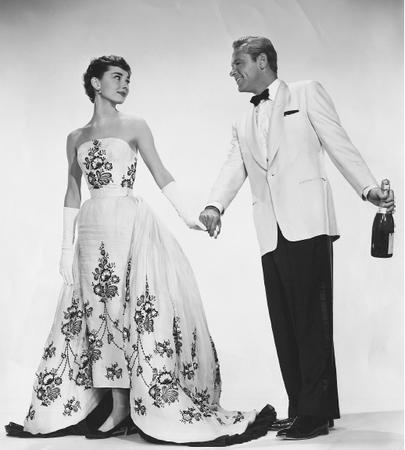 Audrey Hepburn, with William Holden, in a publicity still from the film Sabrina (1954) wearing a gown designed by Hubert de Givenchy. © Bettmann/CORBIS.