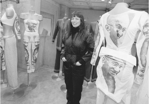 Norma Kamali standing in her Manhatten showroom with part of her spring 1997 line, featuring silkscreens of Mahatma Ghandi. © AP/Wide World Photos.