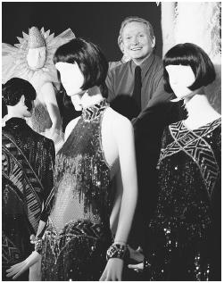 Bob Mackie posing with some of his designs at the "Unmistakably Mackie" retrospective at the Fashion Institute of Technology in New York, 1999. © AP/Wide World Photos.